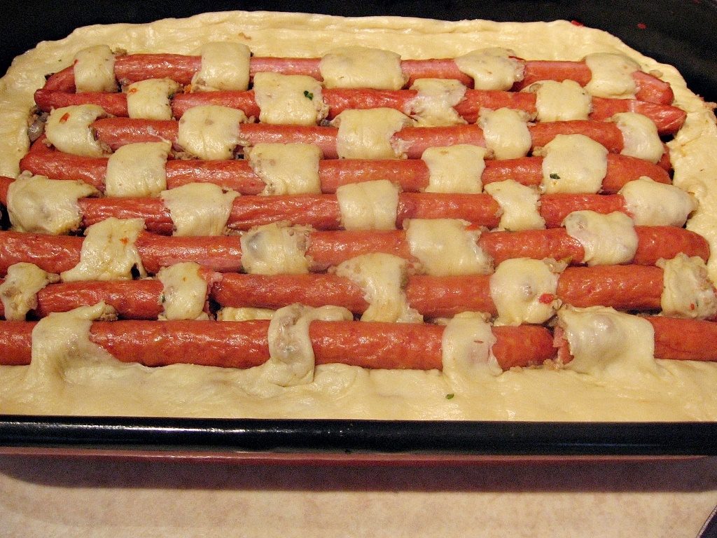 Placinta impletita cu carnati inainte de coacere