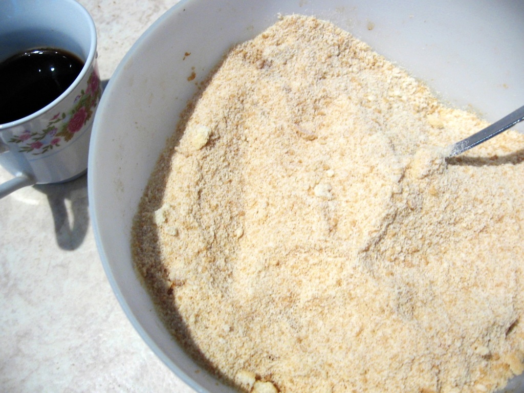 Piscoturi cu alune maruntite intr-un bol si o ceasca de cafea