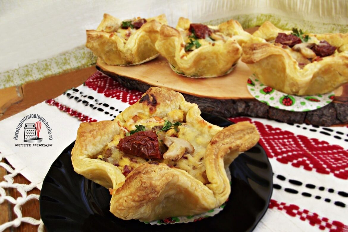 Cosulete aperitiv din foietaj cu bacon si ciuperci pe un platou de lemn si pe o farfurie neagra