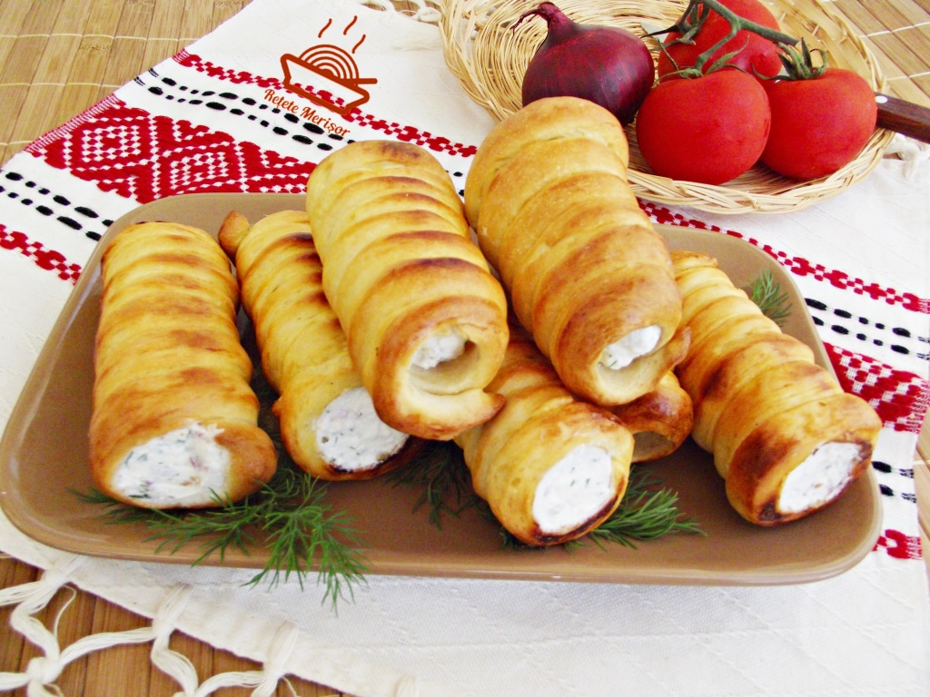 Rulouri aperitiv cu crema de branza pe un platou cu crengute de marar, alaturi de un cos cu legume Rulouri aperitiv cu crema de branza pe un platou cu crengute de marar, alaturi de un cos cu legume