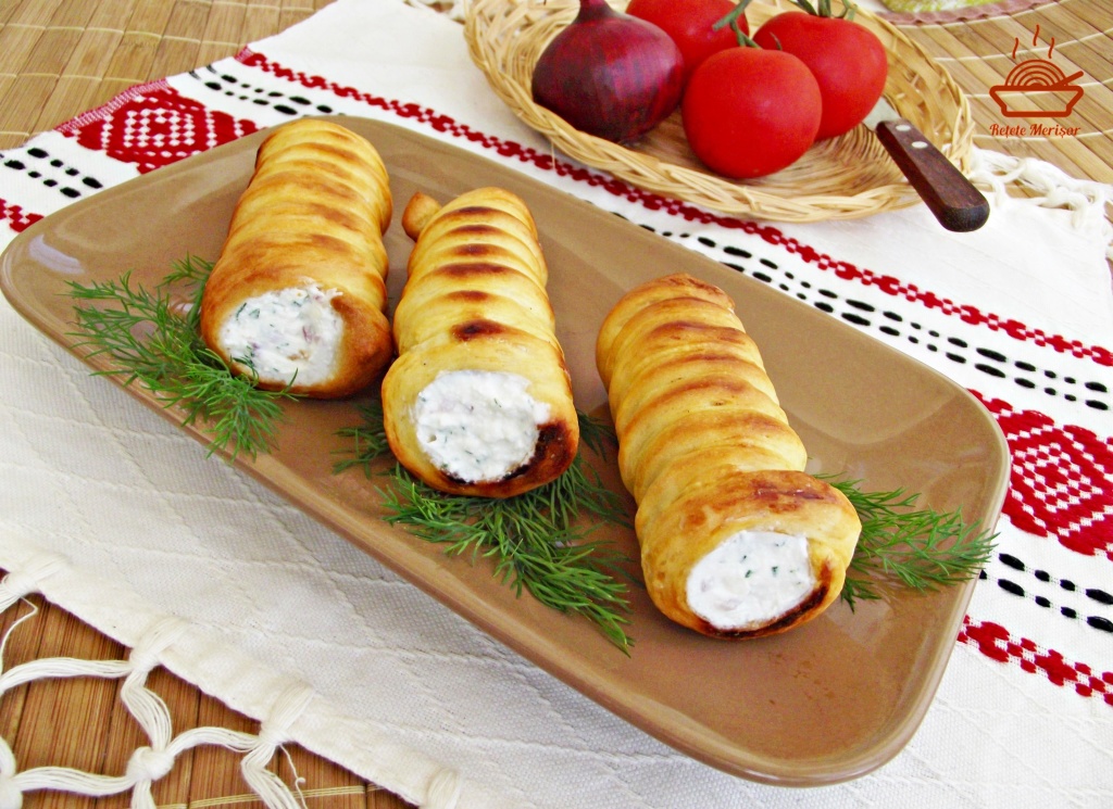 Trei rulouri aperitiv cu crema de branza si marar pe un platou cu crengute de marar si un cos cu legume si cutit Trei rulouri aperitiv cu crema de branza si marar pe un platou cu crengute de marar si un cos cu legume si cutit
