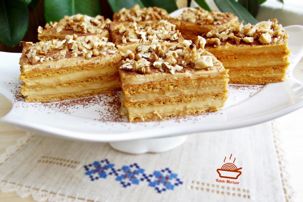 Prajitura Deliciu cu caramel portionata pe un platou cu picior