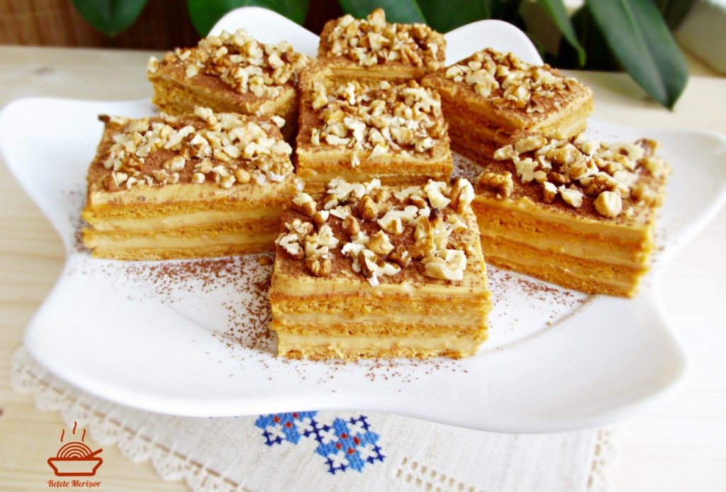 Prajitura Deliciu cu caramel portionata pe un platou cu picior