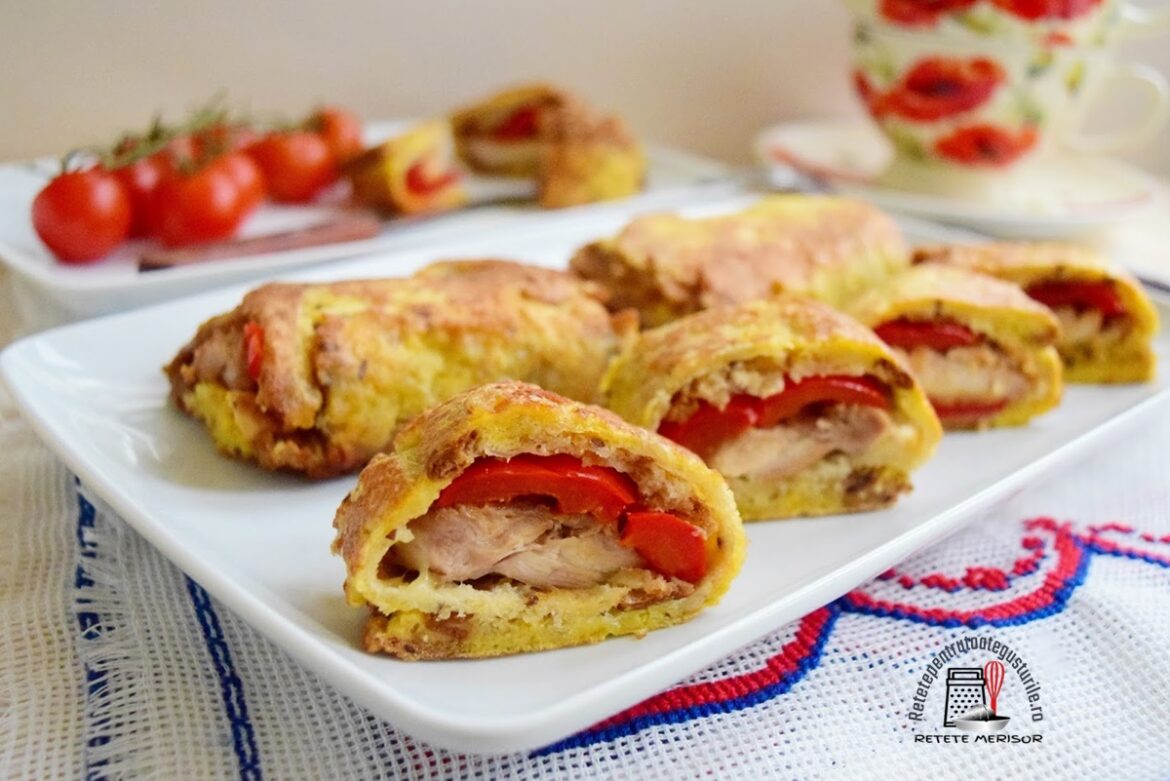 Rulouri pane cu pui si gogosari sectionate pe un platou alb, alaturi de un platou cu rosii cherry si doua cesti cu imprimeuri de maci