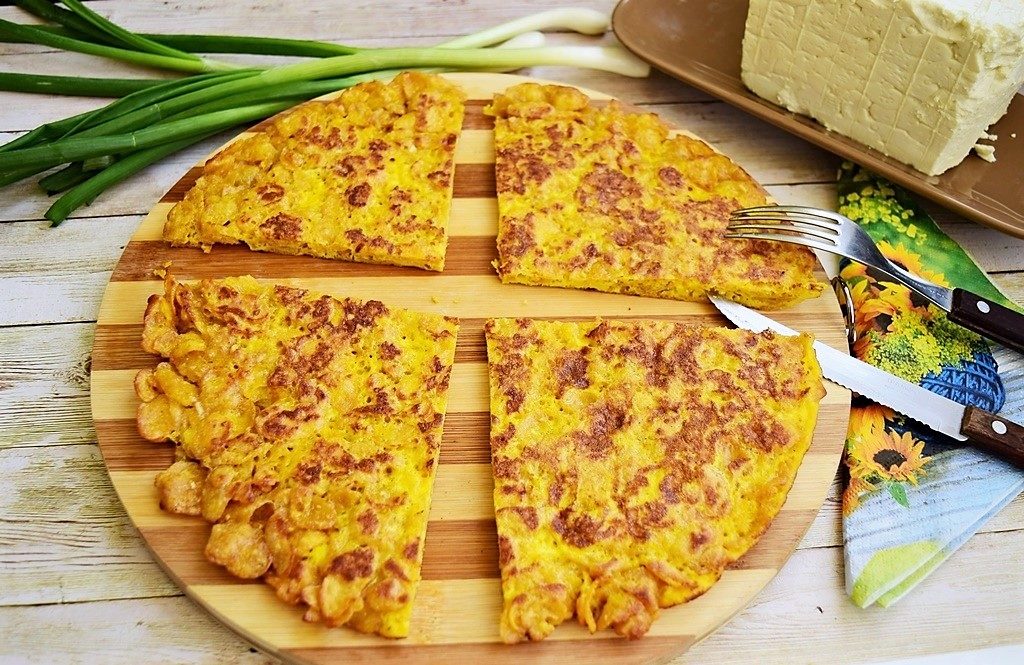 Omletă cu fulgi de porumb porționată pe un suport de lemn rotund