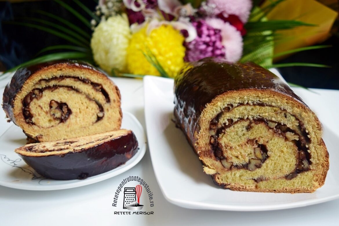 Cozonac de post cu suc de portocale și glazură de cacao porționat pe două platouri și un buchet de flori în spate