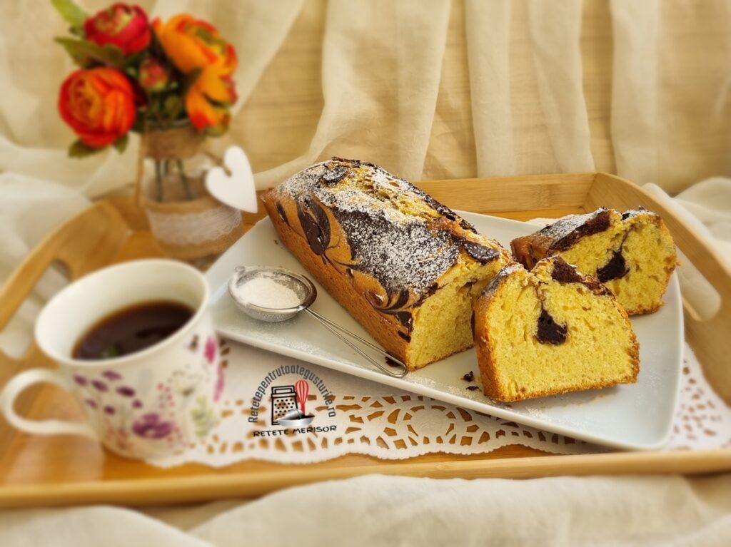 Chec simplu și economic feliat pe un platou alb, alături de o ceașcă cu cafea și o vază cu trandafiri