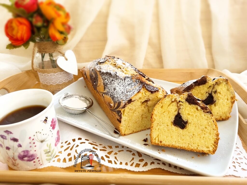 Chec simplu și economic feliat pe un platou alb, alături de o ceașcă cu cafea și o vază cu trandafiri