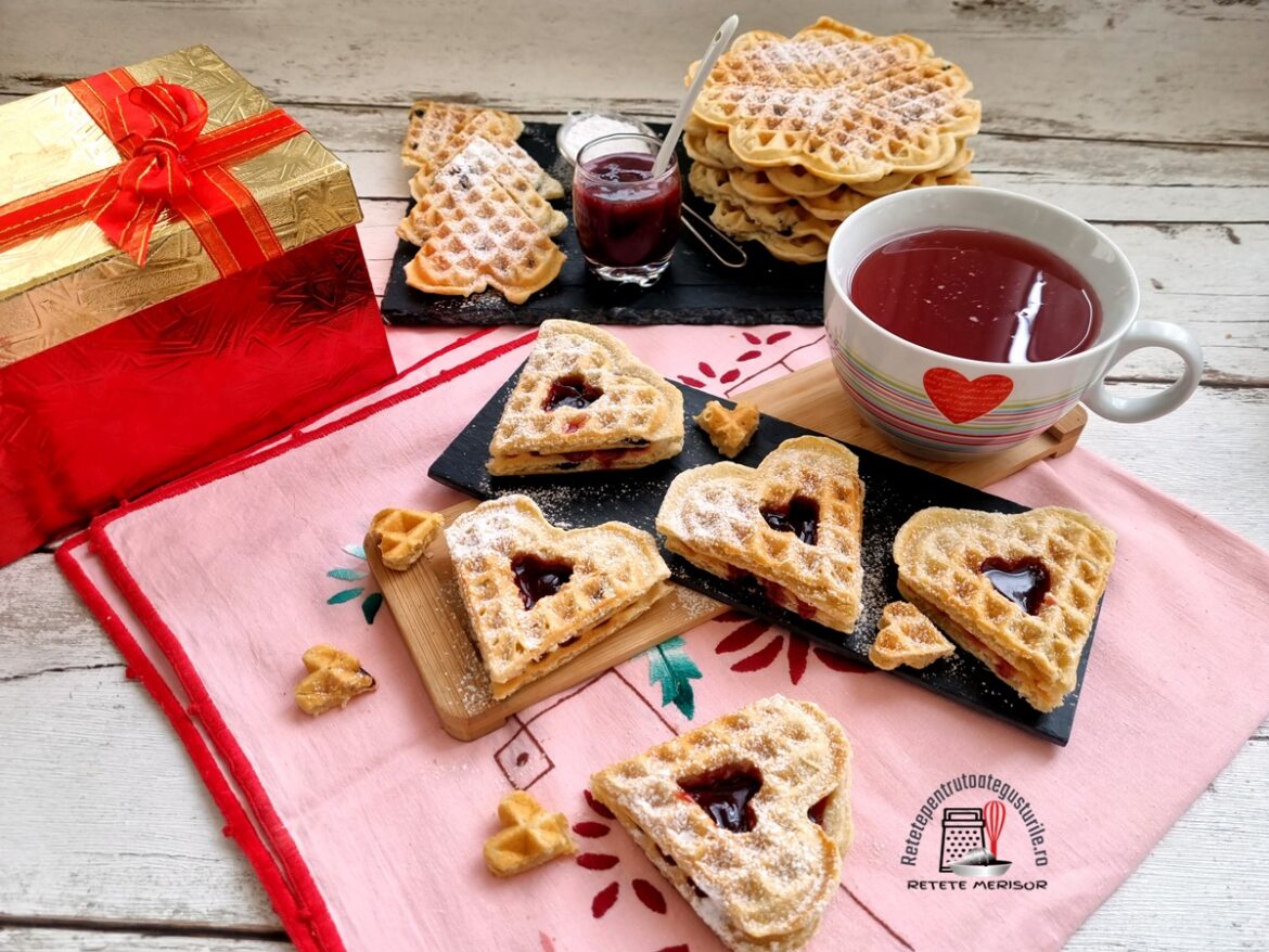 Vafe inimioare cu cocos și jeleu de vișine alături de o cană cu ceai și o cutie de cadouri