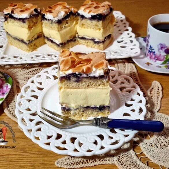 Prăjitura Pani Walewska porționată pe un platou alb dantelat și pe o farfurie albă dantelată cu furculiță, alături de două cești de cafea