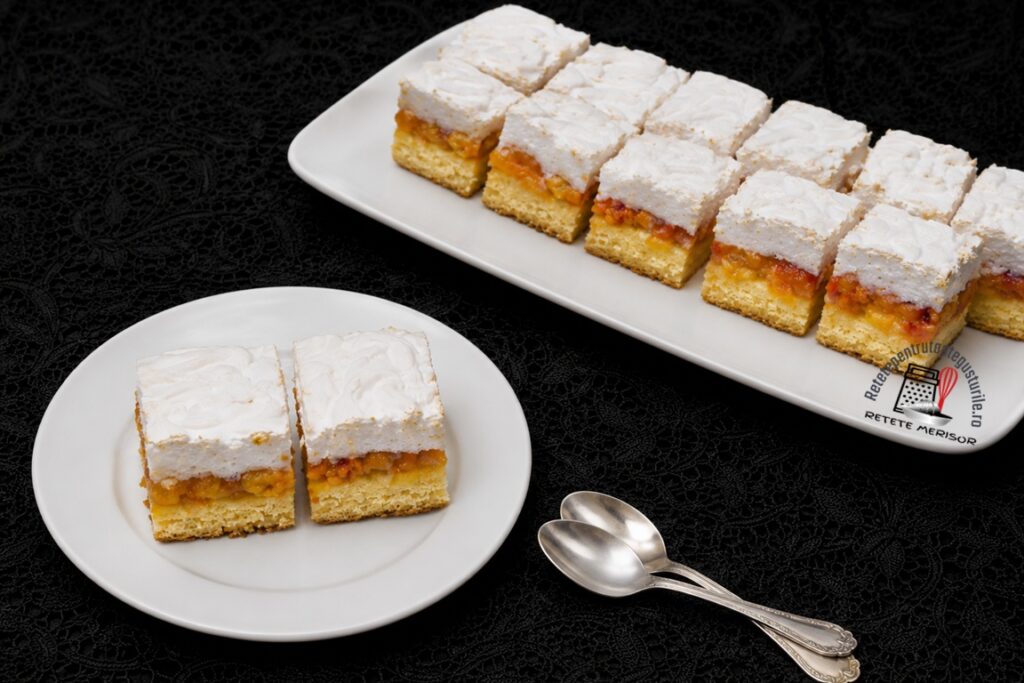 Porții de prăjitură cu caise și bezea pe platou și farfurie